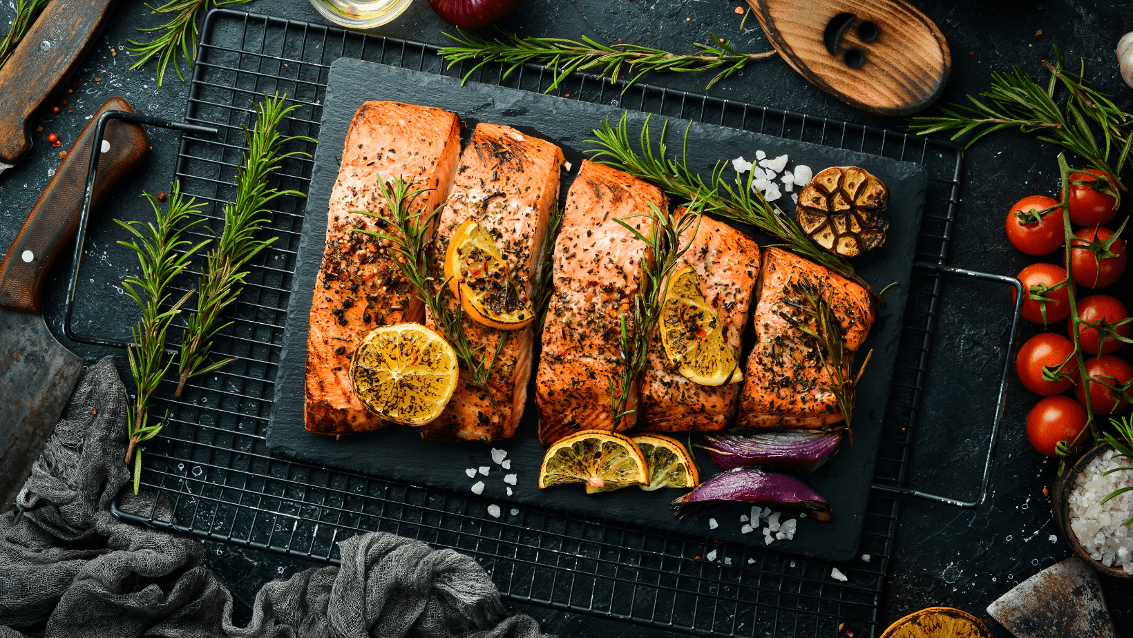 Salmon. Pieces of grilled fish on a black stone background. Recipe. Seafood. Free space for text.