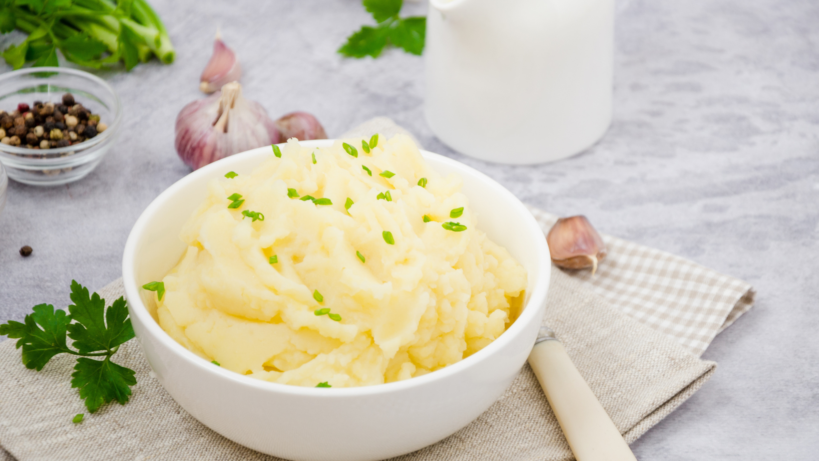 Vegan Mashed potatoes with butter, milk, garlic and green onions in a bowl on a gray background. A traditional dish of Ukrainian, Russian cuisine