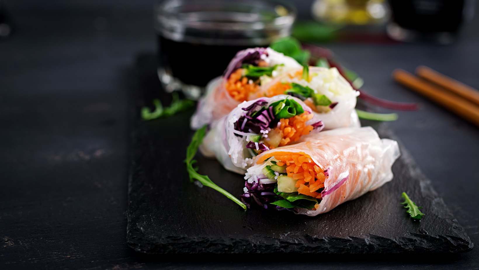 Vegetarian vietnamese spring rolls with spicy sauce, carrot, cucumber, red cabbage and rice noodle. Vegan food. Tasty meal.