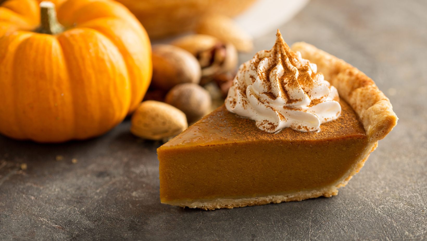 Traditional pumpkin pie topped with whipped cream